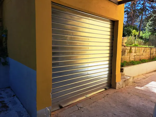 Serranda in acciaio zincato rimessa in funzione all'ingresso di un garage – riparazione serrande ad Arzergrande